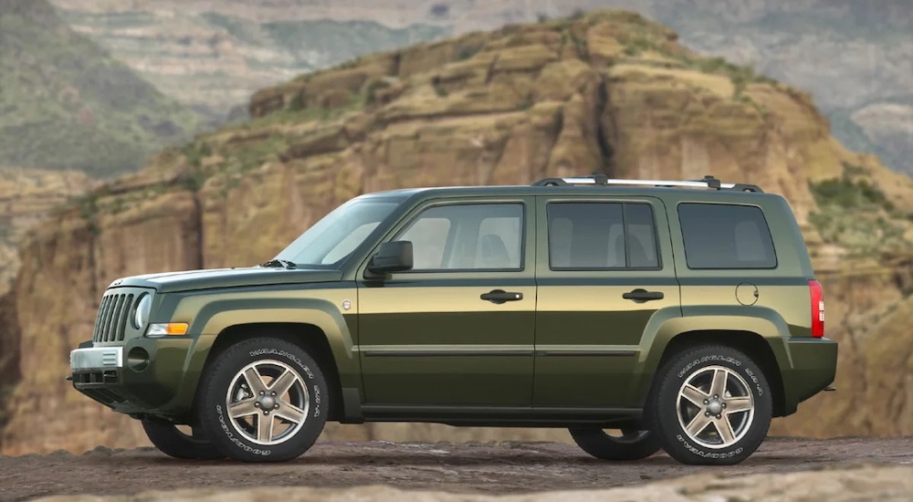 A green 2007 Jeep Patriot parked in a canyon.