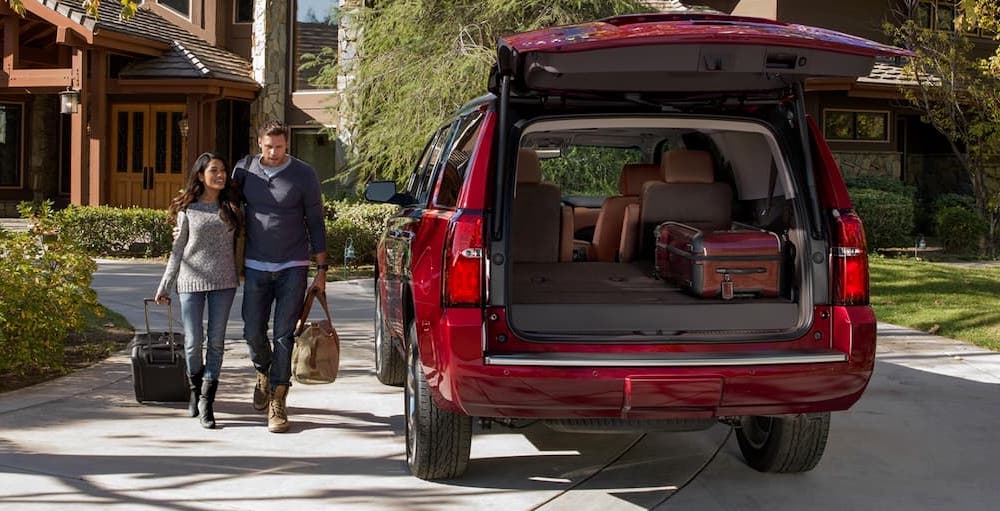 A red 2020 Chevy Tahoe is shown from the rear in a driveway.