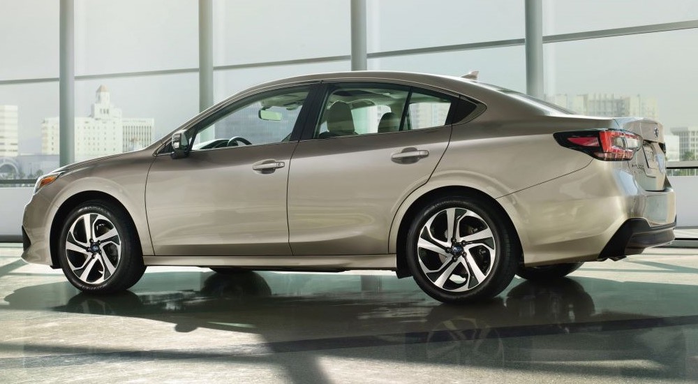 A tan 2020 Subaru Legacy parked in a used car showroom.